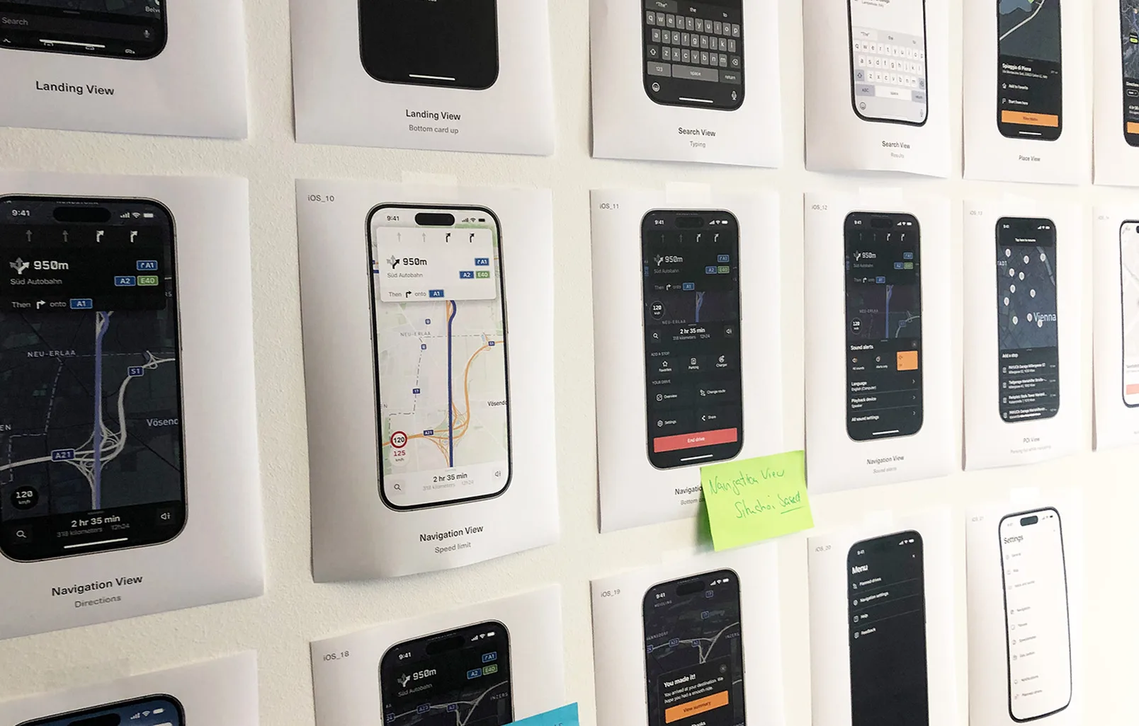 Close-up of printed app screens annotated with sticky notes during a review