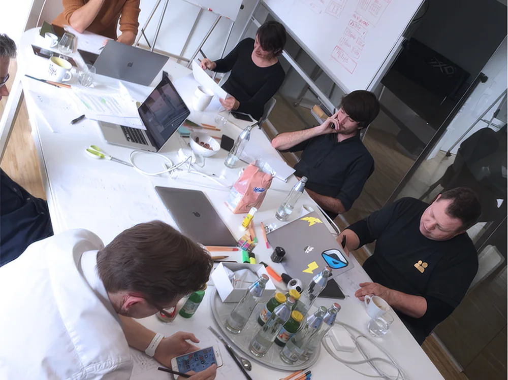 Team members reviewing notes and sketches around a shared table